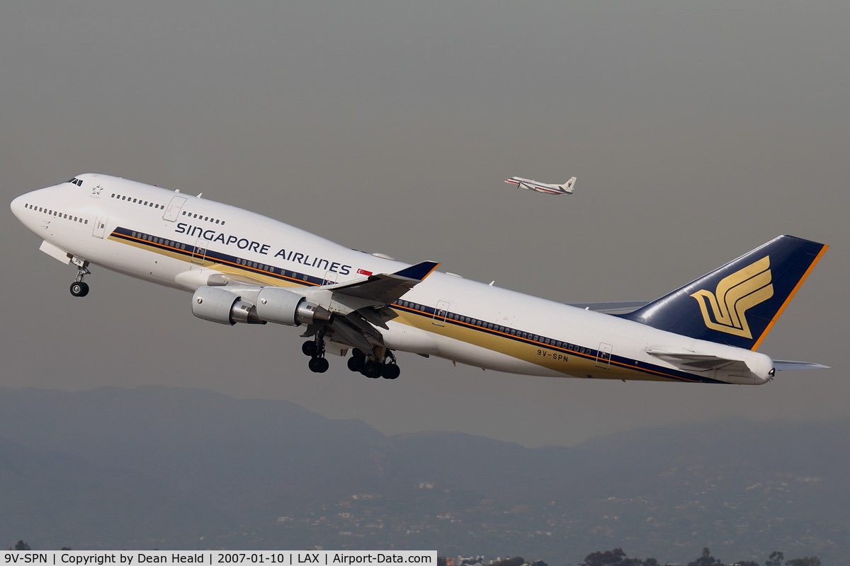 9V-SPN, 2001 Boeing 747-412 C/N 28031, Singapore Airlines 9V-SPN (FLT SIA11) climbing out from RWY 25R on a hazy day enroute to Narita Int'l (RJAA), Japan, with an American Eagle Saab 340 simultaneously climbing out from RWY 24L.