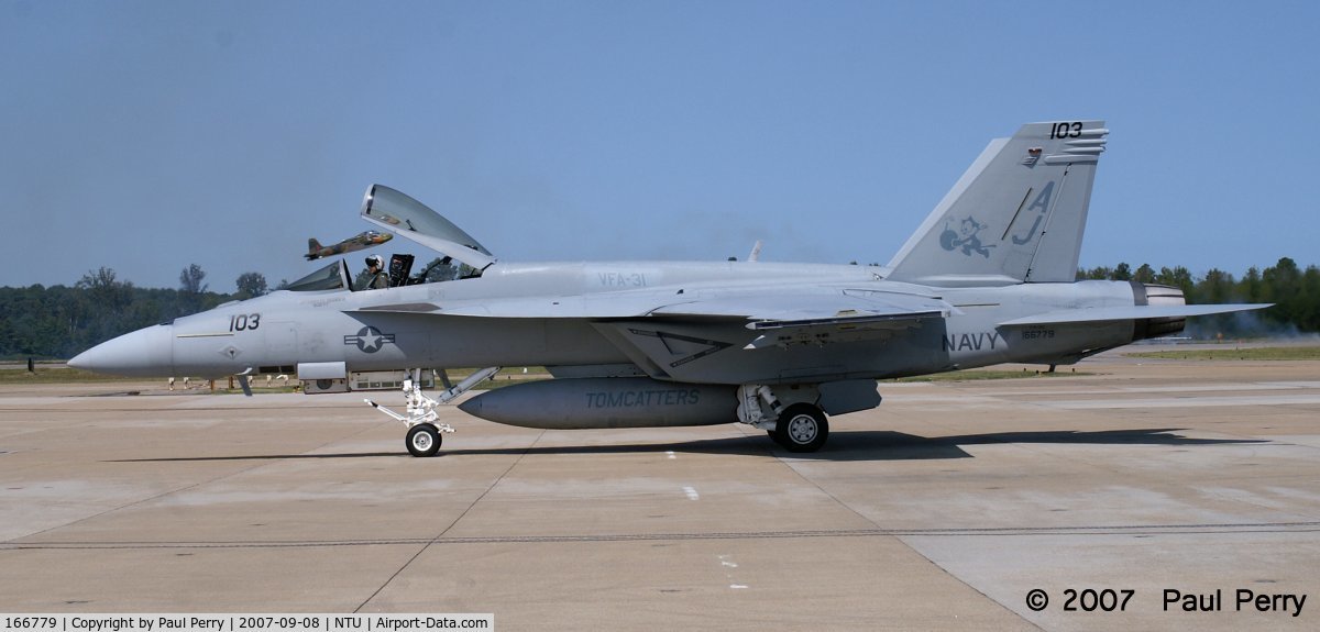 166779, 2006 Boeing F/A-18E Super Hornet C/N E125, As she comes in, the Strikemaster is taking off (see canopy)