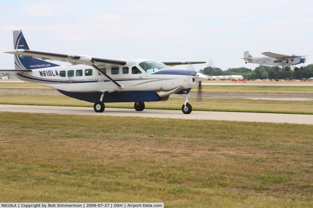 N610LA, 2004 Cessna 208B C/N 208B1060, Arriving at Airventure 2009 with N8407 landing in the background - Oshkosh, Wisconsin