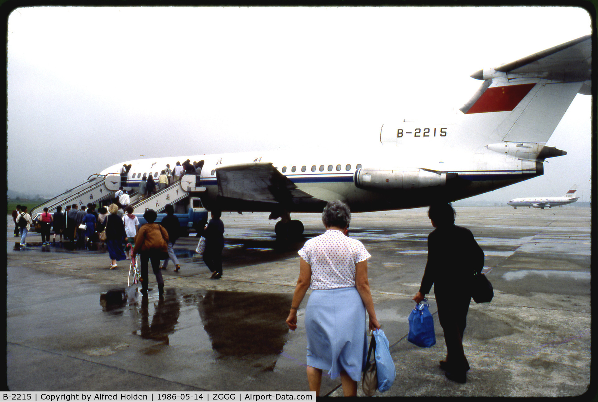 B-2215, 1972 Hawker Siddeley HS-121 Trident 2E-107 C/N 2166, Chinese passengers and Western tourists walk toward one of CAAC's British-built Trident jets, B-2215, in order to board a flight from Guangzhou to Guilin. Taken at Guangzhou Baiyun International Airport in May of 1986. Scanned from a Kodachrome slide.