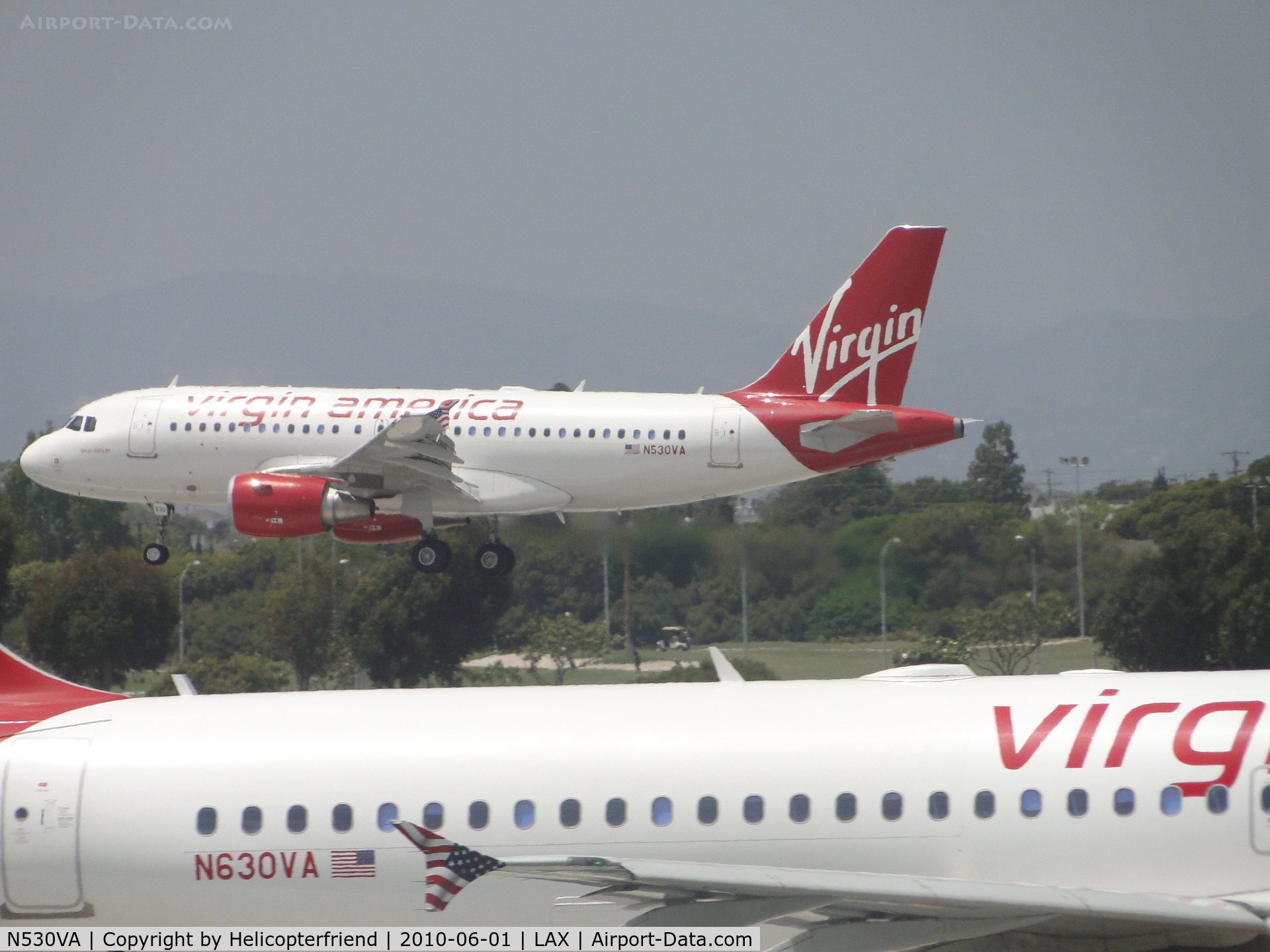 N530VA, 2008 Airbus A319-115 C/N 3686, N530VA landing on runway 24R while N630VA awaits to take off on runway 24L