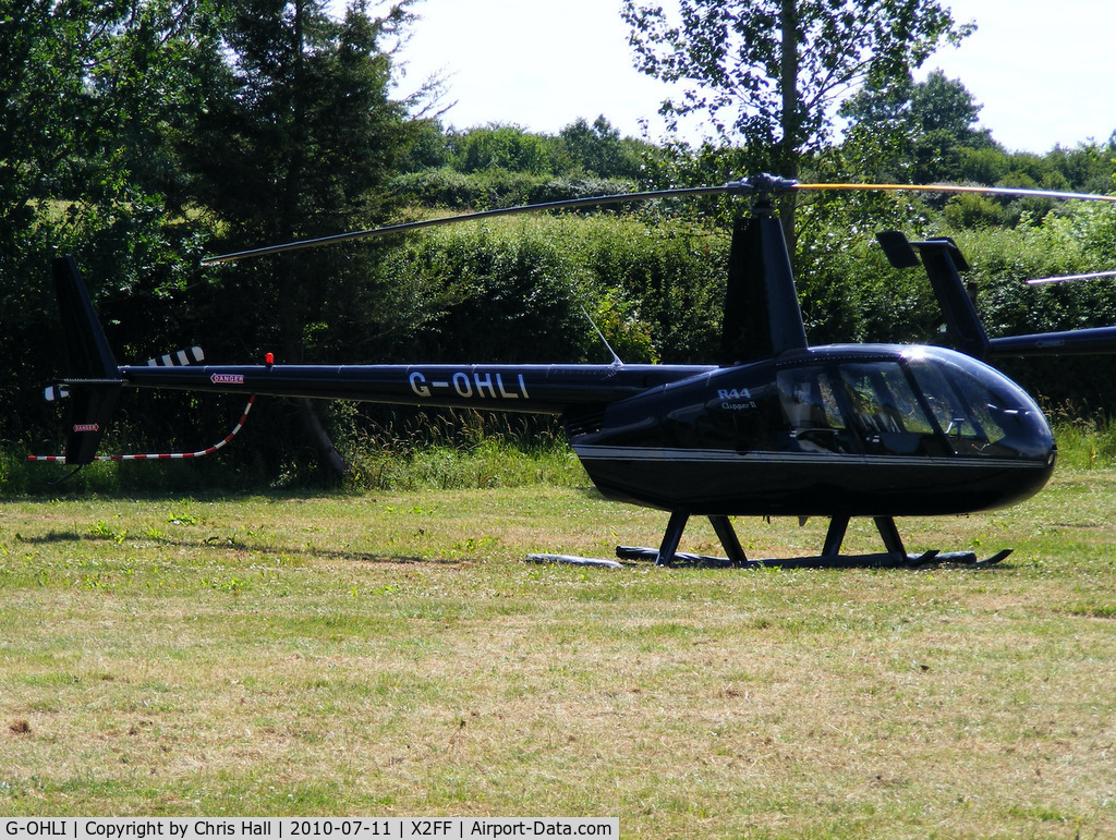 G-OHLI, 2005 Robinson R44 Clipper II C/N 10832, Robinson R44 being used for ferrying race fans to Silverstone for the British Grand Prix from this temporary heliport a few miles east of Bicester