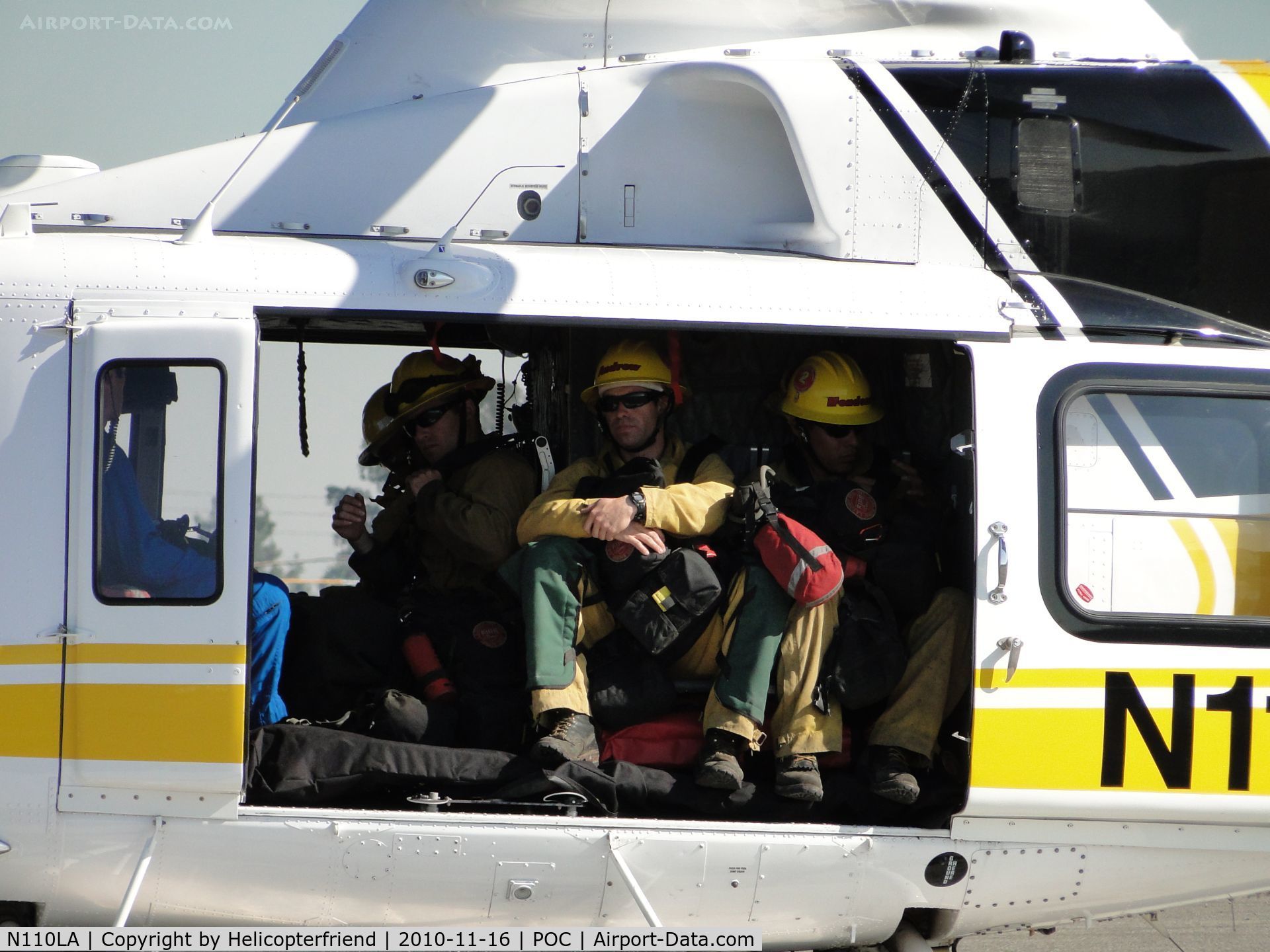 N110LA, 2005 Bell 412EP C/N 36392, Fire fighters on board and recieving instructions from helicopter crew member
