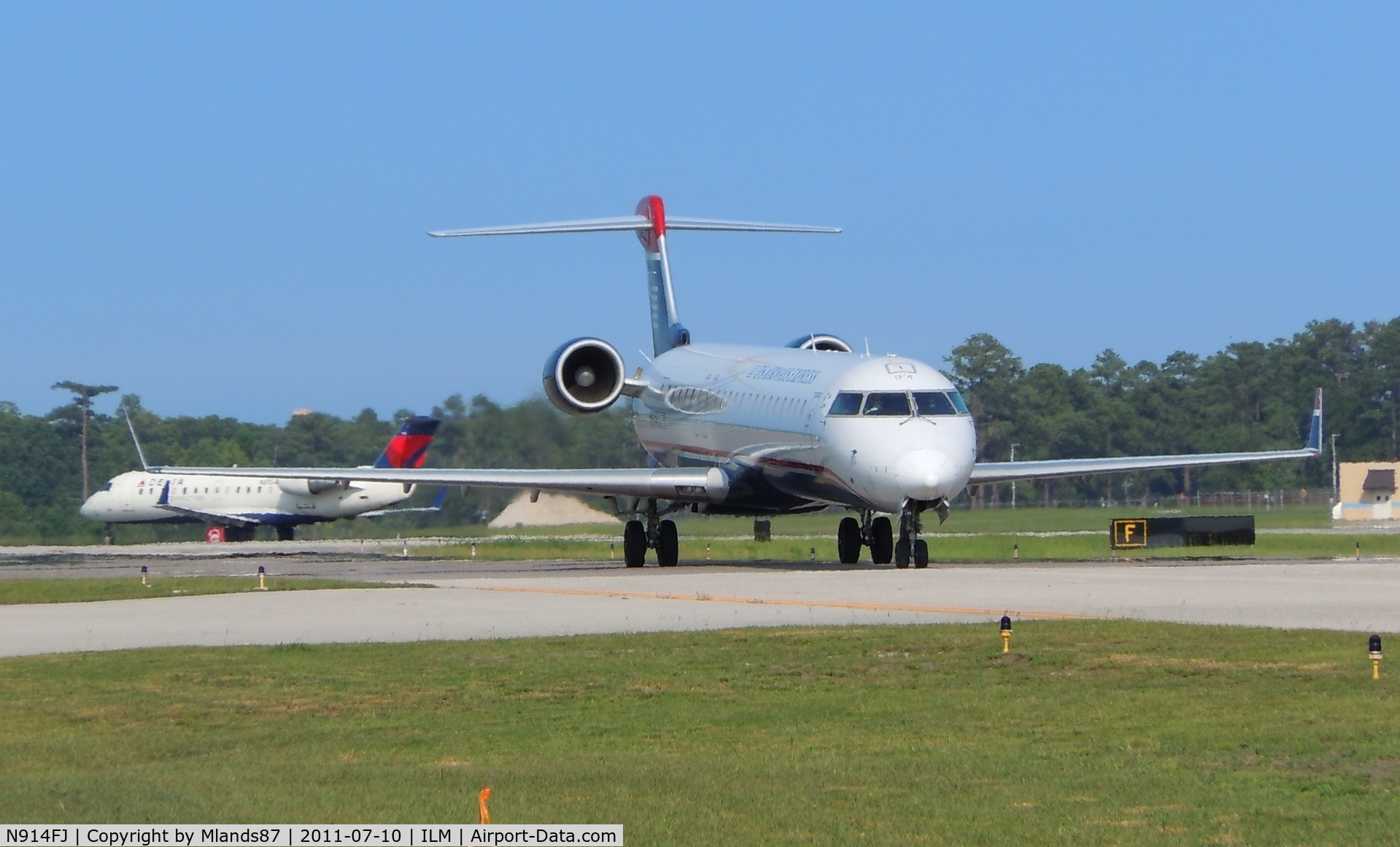 N914FJ, 2004 Bombardier CRJ-900ER (CL-600-2D24) C/N 15014, CL 600 taxiing to gate with traffic taking off