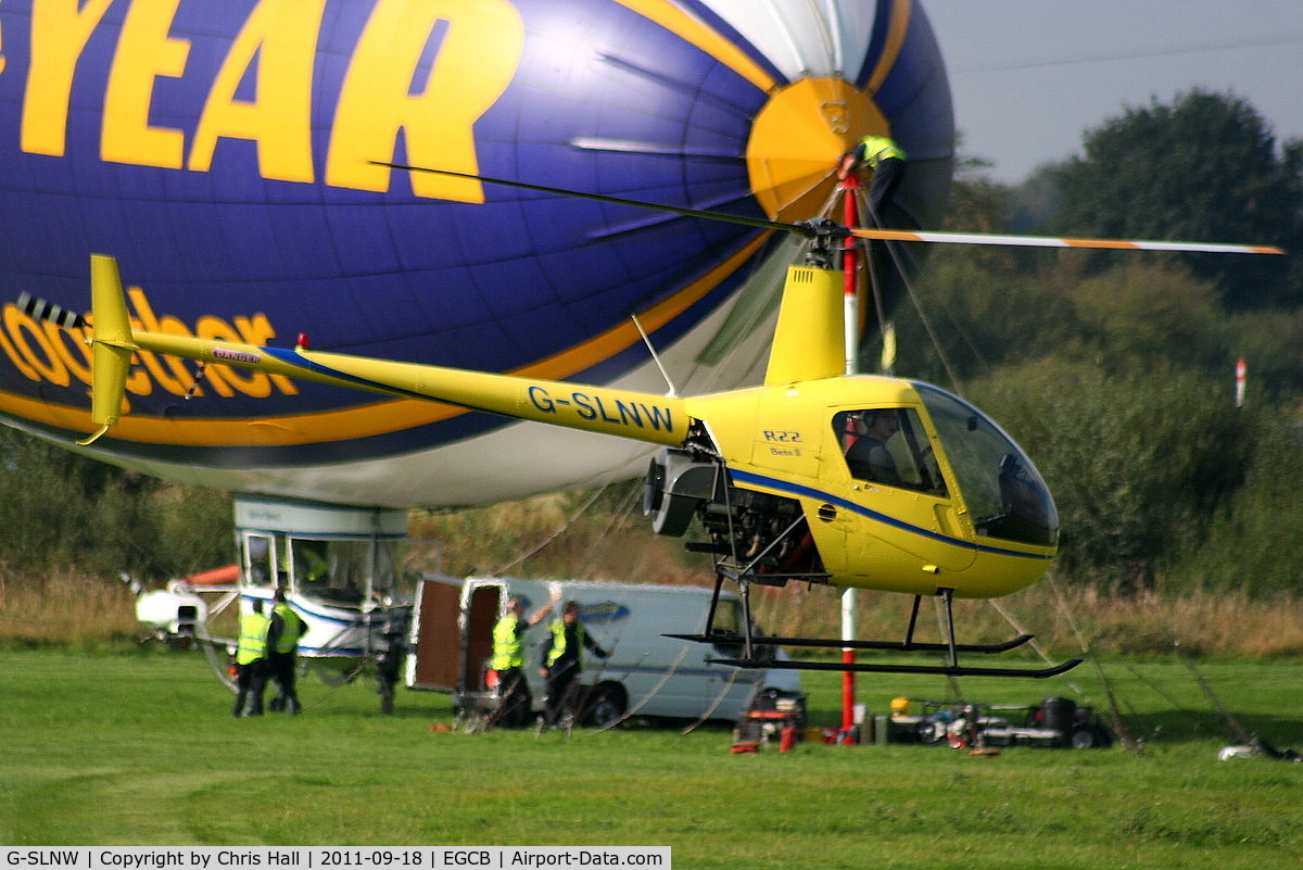 G-SLNW, 2003 Robinson R22 Beta II C/N 3524, R22 in a taxi hover past the Goodyear Airship