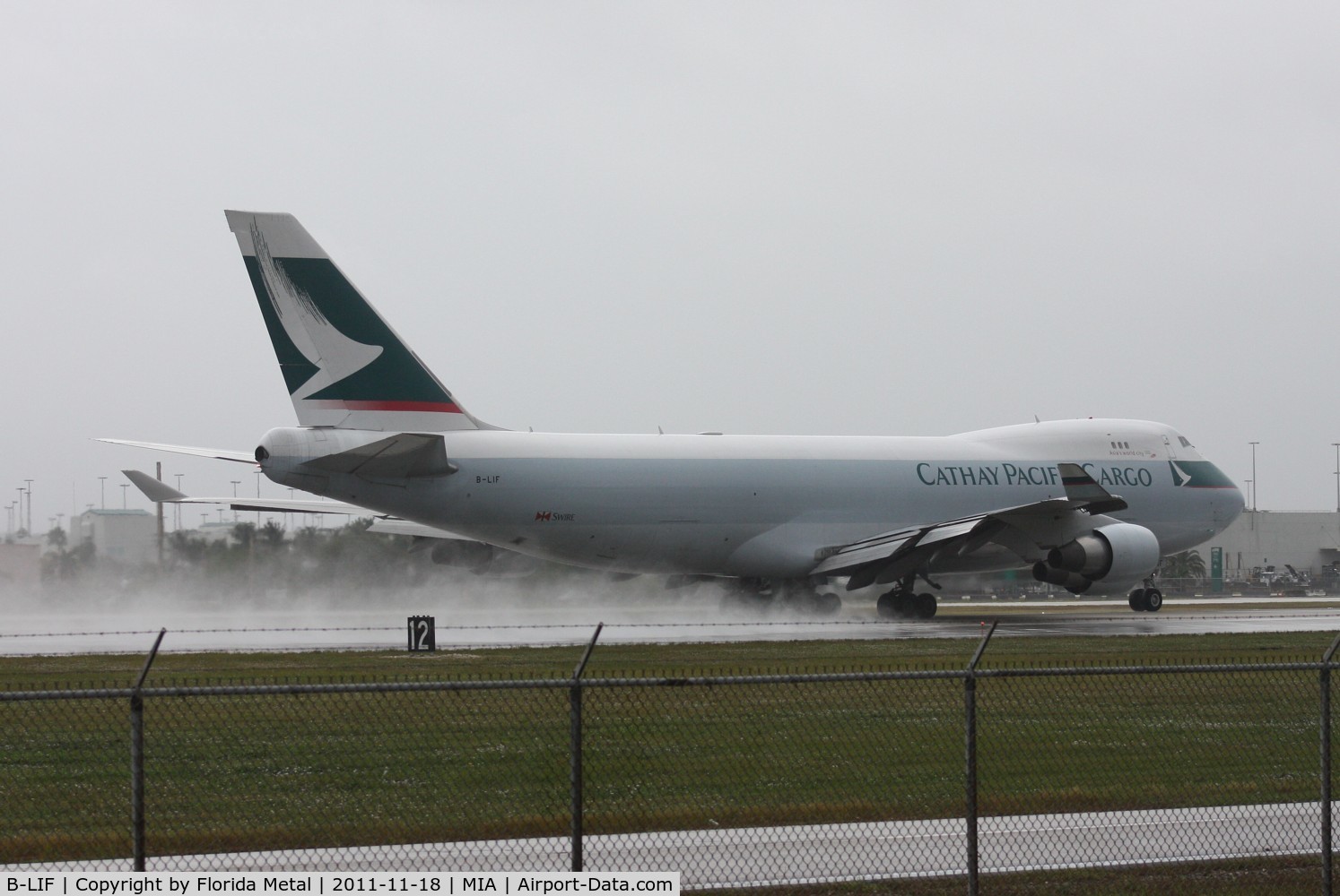 B-LIF, 2009 Boeing 747-467ERF C/N 36871, Cathay Cargo kicking up rain on the runway