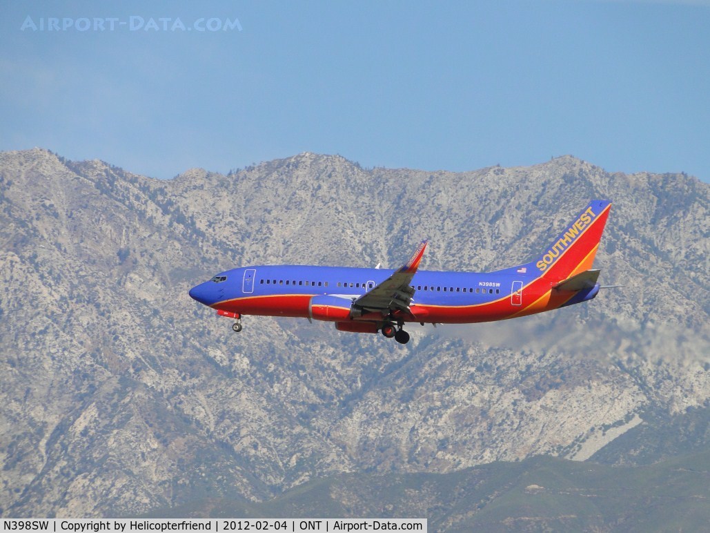 N398SW, 1995 Boeing 737-3H4 C/N 27692, Approaching the outer fence of runway 26R, below the mountains north of the airport