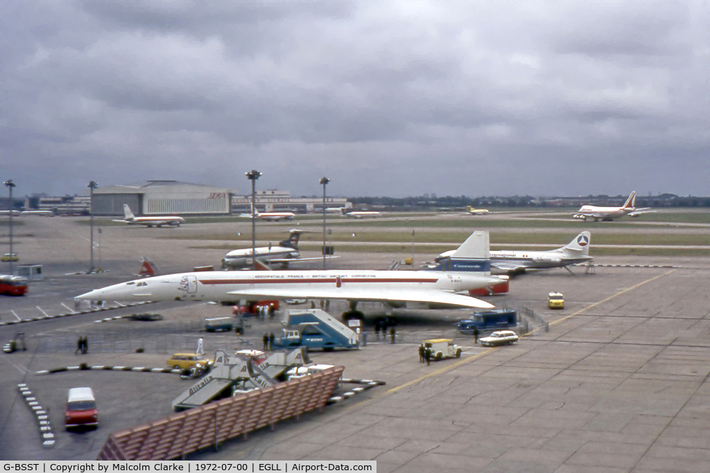 G-BSST, 1966 Aerospatiale-BAC Concorde Prototype C/N 002/13520, Concorde prototype 002 at London Heathrow on its return from a Far East sales tour. In front of the forward door are the flags of the nations visited. Also seen are two 707's, two Tridents, a 747, a Caravelle and a 727.