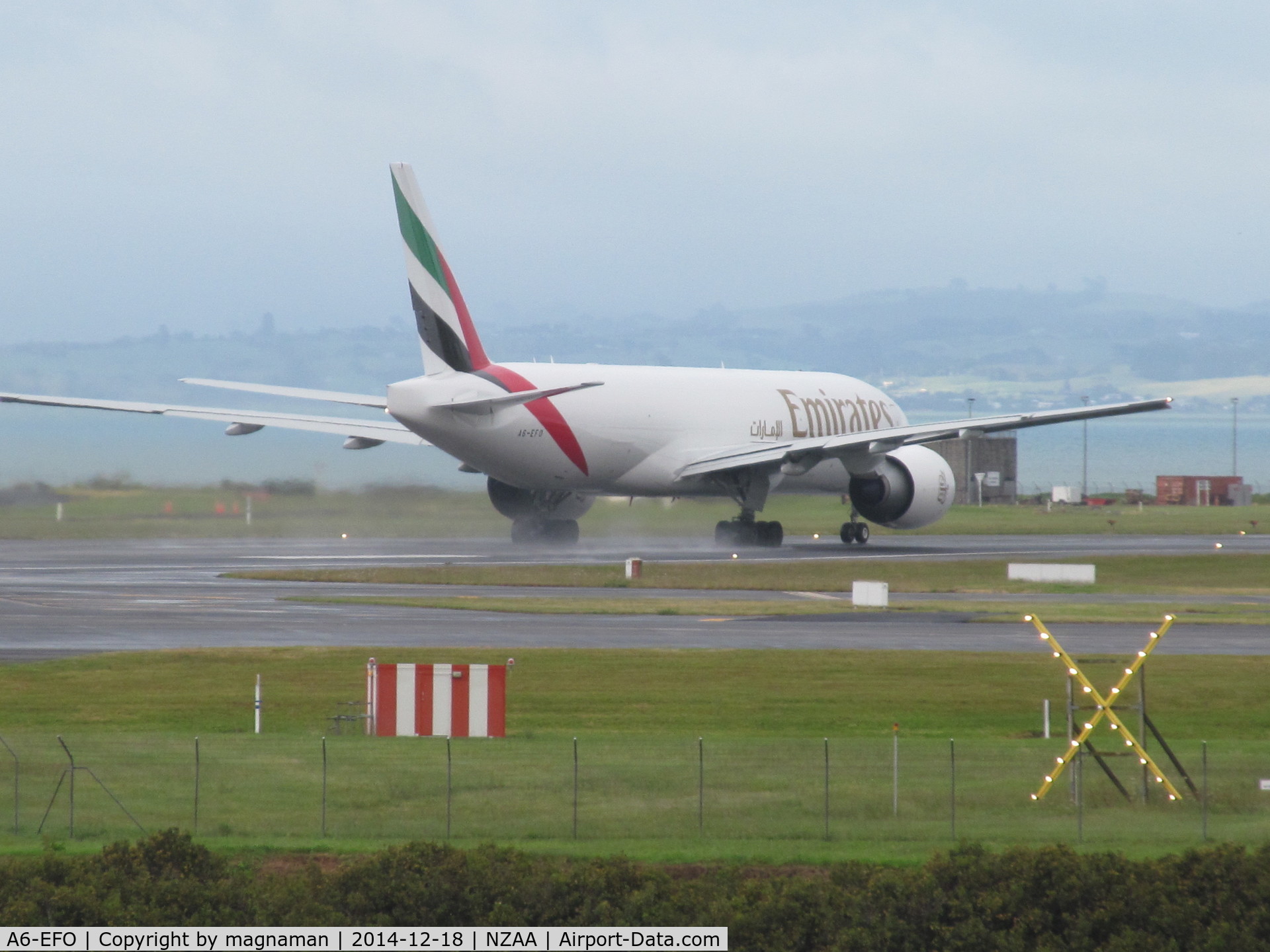 A6-EFO, 2014 Boeing 777-F1H C/N 42233, departing on wet runway
