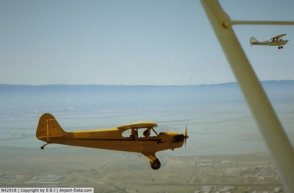 N42918, 1945 Piper J3C-65 Cub C/N 15254, Cub 918 with Champ 25E top right flying in the S F Bay Area. View is to the west with Moffett Field (NUQ) seen in the distance above the tail of 918..
