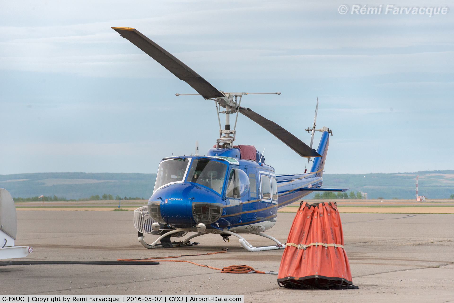 C-FXUQ, 1975 Bell 205A-1 C/N 30176, Parked by control tower. Fighting forest fires during the day. With sling bucket.