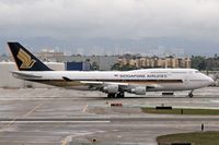 9V-SPF @ LAX - Singapore Airlines 9V-SPF starting her takeoff roll on RWY 7L on a wet day. - by Dean Heald