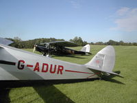 G-ABLS @ IA27 - De Havilland Puss Moth framed by a Hornet Moth while visiting Antique Airfield near Blakesburg, IA - by BTBFlyboy