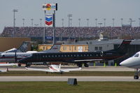N138DE @ DAB - Dale Earnhart Inc's new E145 parked with Daytona Speedway in background - by Florida Metal
