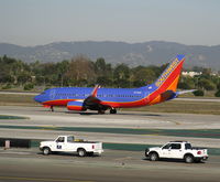N739GB @ LAX - Wanna Race?! Southwest 1998 Boeing 737-7H4 in new colors w/winglets holding on RW 24L - by Steve Nation