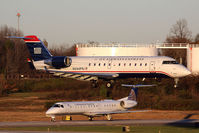 N244PS @ CLT - US Airways Express N244PS (FLT JIA392) from Columbia Metropolitan Airport (KCAE) South Carolina landing RWY 18C, while a Continental Express (ExpressJet) ERJ holds short. - by Dean Heald
