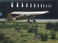G-BJSZ @ EGFH - Through the fence. Classic Piper Cub basking in the morning sun. - by Roger Winser