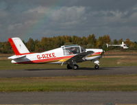 G-AZKE @ EGLK - Rallye Club taxying past the cafe with R22 G-CBWZ manouvering behind - by BIKE PILOT
