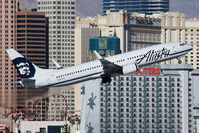 N323AS @ LAS - Alaska Airlines N323AS (FLT ASA619) climbing out from RWY 1R en route Seattle-Tacoma Int'l (KSEA), with the Monte Carlo Hotel and the Hooters Hotel in the background. - by Dean Heald