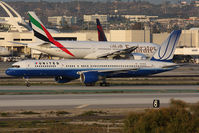 N519UA @ LAX - 20 Years Old - United Airlines N519UA (FLT UAL69) on Taxiway Papa holding short of RWY 25R after arrival from Dever Intl (KDEN) on RWY 25L, with Emirates A6-EWE taxiing to RWY 25R for departure to Dubai. - by Dean Heald