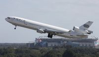 N277WA @ TPA - World MD-11 in front of Raymond James Stadium, home of the Tampa Bay Buccaneers NFL team - by Florida Metal