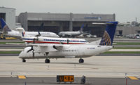 N209WQ @ KEWR - A United commuter joins the crowd waiting to vacate the main apron at Newark after a downpour delayed countless flights. - by Daniel L. Berek