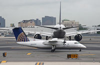 N351PH @ EWR - Strolling behind a United Triple-7, this Dash-8 shows off the amazing difference in size between these two aircraft. - by Daniel L. Berek