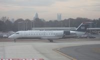 N444ZW @ CLT - US Airways Express CRJ - taken out of the window of the US Airways A319 (N744P - Piedmont retro) I was on.  The windows were hazed, not making for the best pictures - Downtown Charlotte in the background