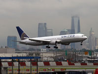 N667UA @ KEWR - The stormy sky and Manhattan skyline provide a dramatic backdrop as this UA Boeing 767 battles bad weather and strong winds to land on Newark's shortest runway. - by Daniel L. Berek