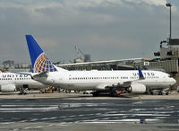 N73291 @ KEWR - Puddles from a recent downpour reflect one of United's ex-Continental Boeing 737s. - by Daniel L. Berek