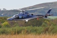 G-WOFM @ EGFH - Visiting helicopter lifting off from Swansea Airport. - by Roger Winser