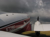 N728G @ KOSH - Waiting for the stormy skies to pas - by steveowen