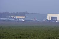 F-GIOK @ LFRD - Air Liberte (middle). Air Deccan ATR to the left, Falcon 20 and two Xingus (French AF) to the right. Behind is another Fokker 100 and a Togo AF Buffalo. - by Howard J Curtis