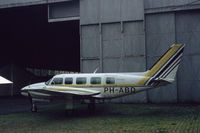 PH-ABD @ EHRD - Piper PA-31-350 Navajo Chieftain of Rijnmond Air Services behind a hangar at Rotterdam Zestienhoven airport, the Netherlands, 1983 - by Van Propeller