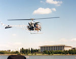 VH-KHM - Heli-Muster Bell 47G-3B-1 helicopter VH-KHM Cn 6629  hovering at Canberra’s Lake Burley Griffin in Mar 1991. (The National Library is visible at rear.) The helo was in town for Canberra Week activities. - by Walnaus47