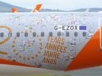 G-EZOX @ EGCC - Airbus A320-214 of easyJet in special '20 years jubilee' colours at Manchester airport. The background seems to be composed of thousands of holiday fotos. - by Ingo Warnecke