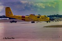 115452 - Buffalo CC-115 115452 at a USAF base. Appears like its getting a prop change. - by Ray Hanson