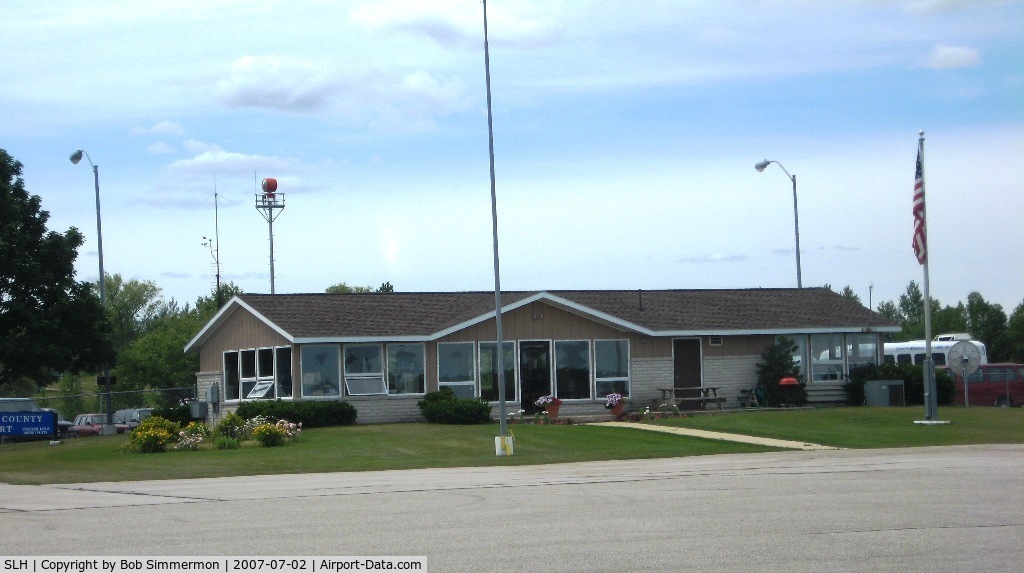 Cheboygan County Airport (SLH) - Terminal at Cheboygan, MI.  Friendly airport and reasonable (relatively speaking) self-serve fuel prices.