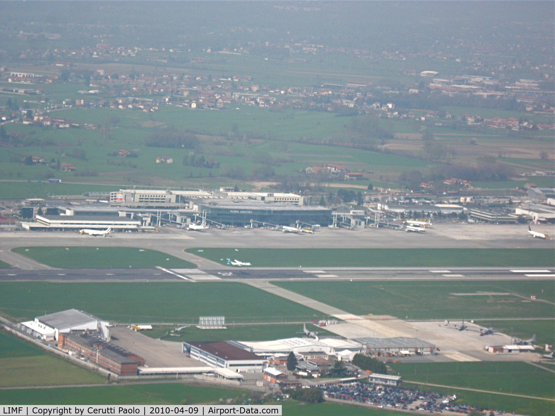 Turin International Airport (Torino Caselle Airport), Turin (Torino) Italy (LIMF) - Overview of Turin airport from the right downwind of runway 36 while an ATR72 of Air Dolomiti is landing.