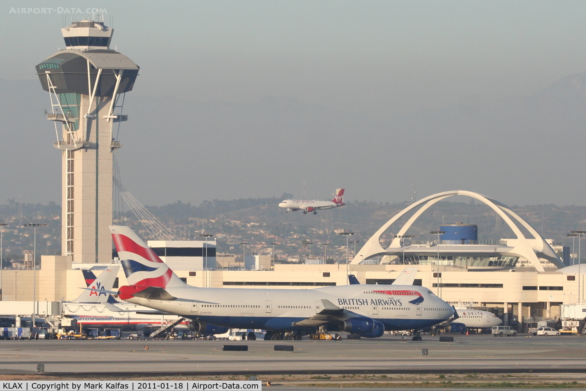 Los Angeles International Airport (LAX) - BA 744 taxiing out on the south complex with a VA A320 landing on the north side.
