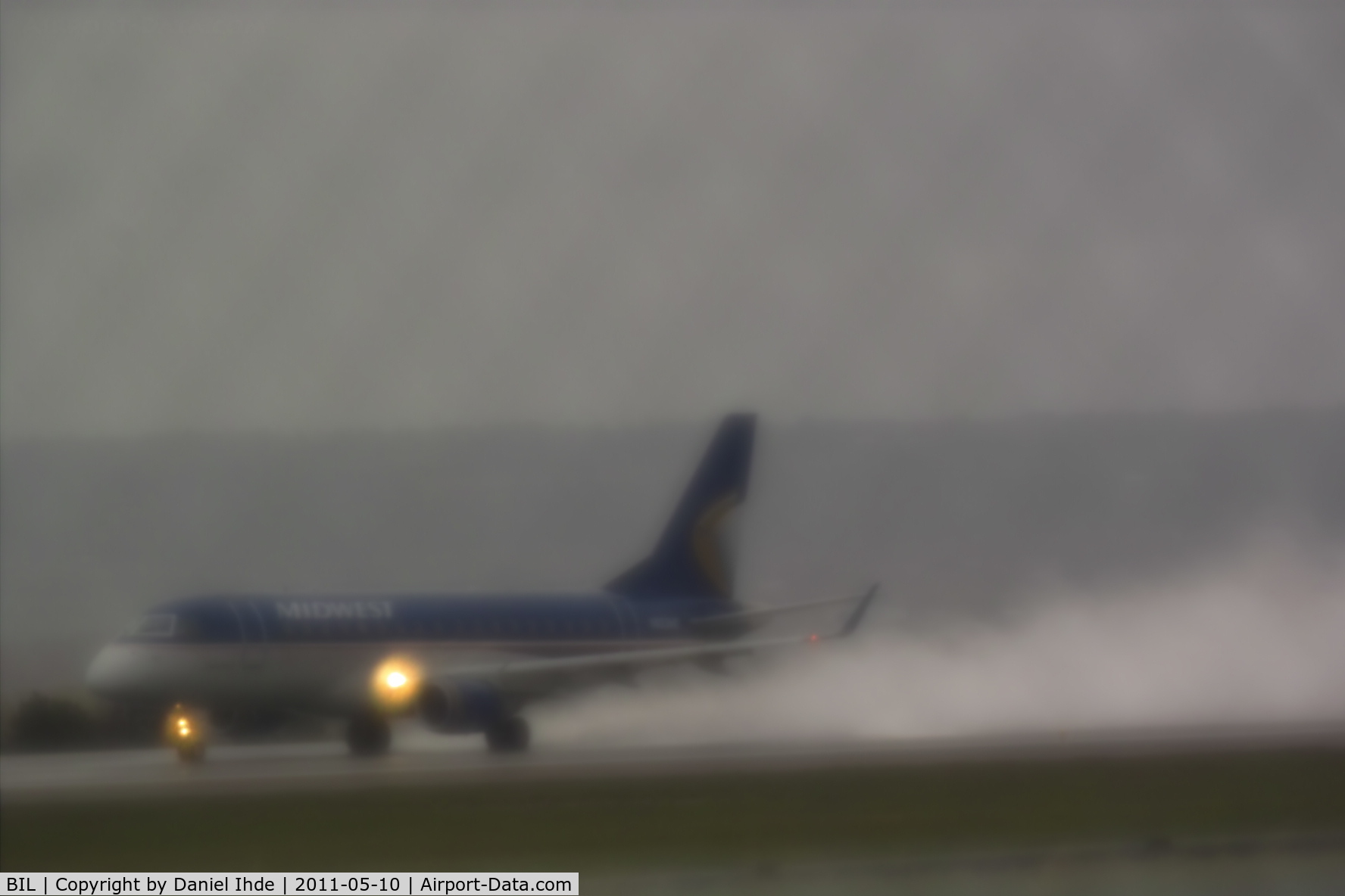 Billings Logan International Airport (BIL) - Frontier Airlines Embraer on 28R during rain storm.  Photo was taken with a 1950's Takumar 200mm screwmount lens with a diffusion filter to create a dreamy effect.