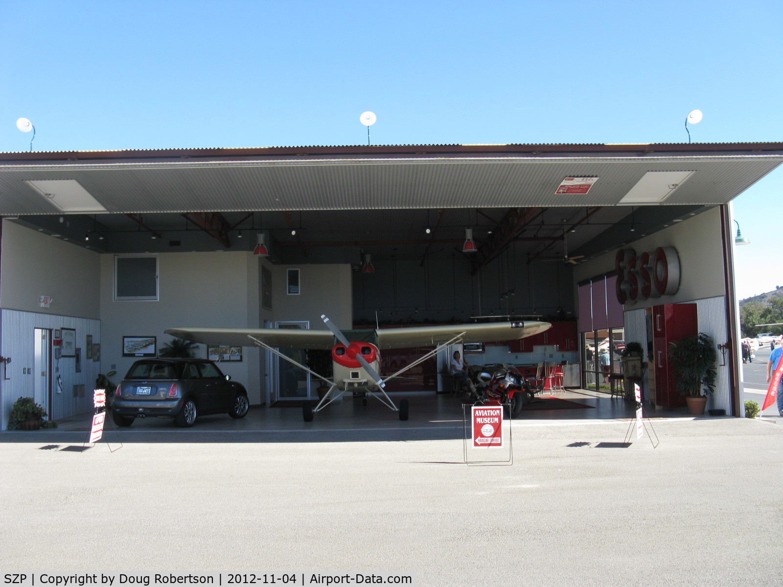Santa Paula Airport (SZP) - Large Deluxe Hangar FOR SALE on corner of Curtiss taxiway and Museum taxiway. Prime midfield location near Fuel Dock. Bifold full-span door open.