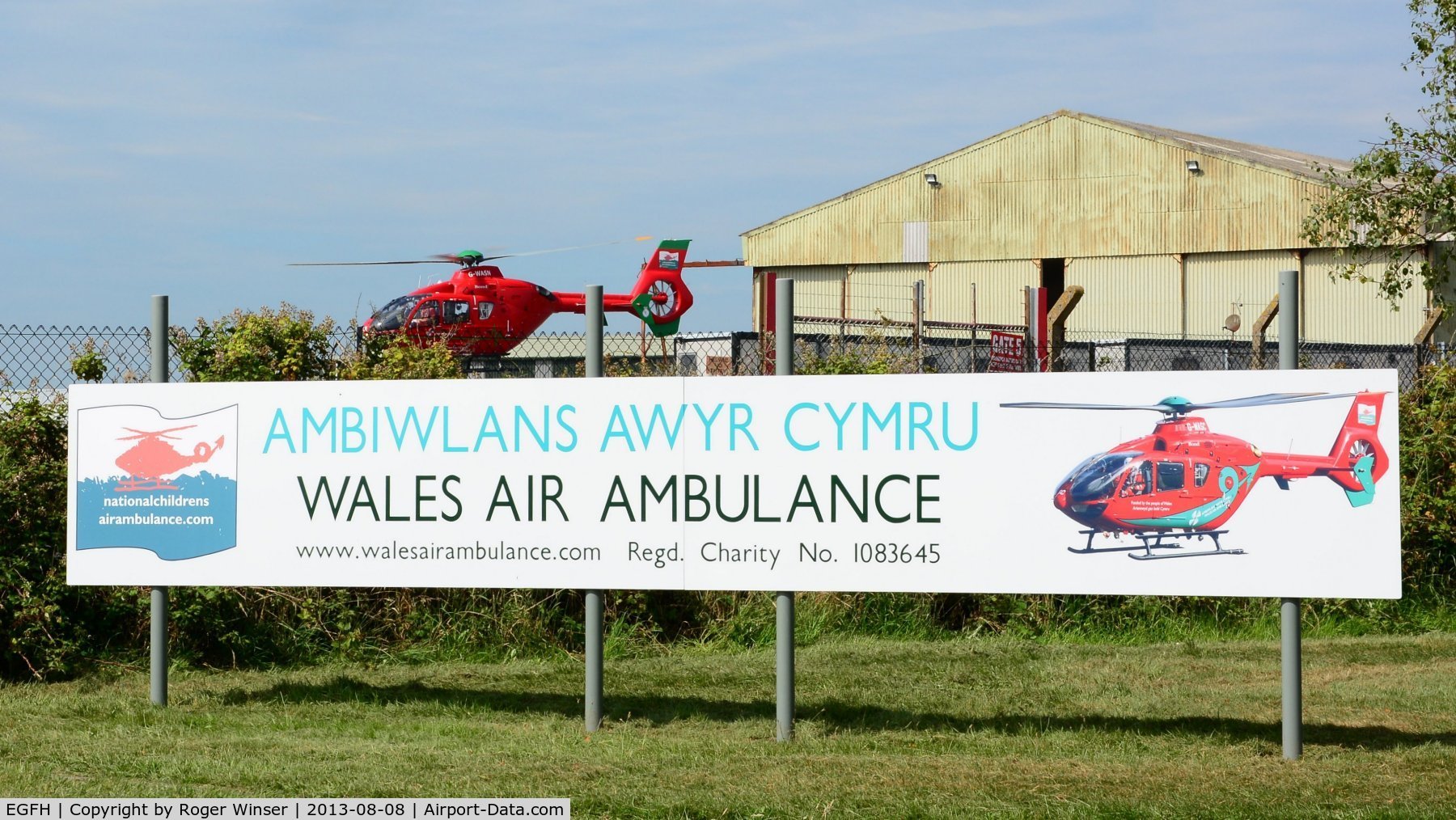 Swansea Airport, Swansea, Wales United Kingdom (EGFH) - Sign by the entrance to Swansea Airport showing the charity (Wales Air Ambulance) funding the three air ambulance helicopters operating in Wales. The Swansea based air ambulance helicopter (Helimed 57) is responding to an emergency