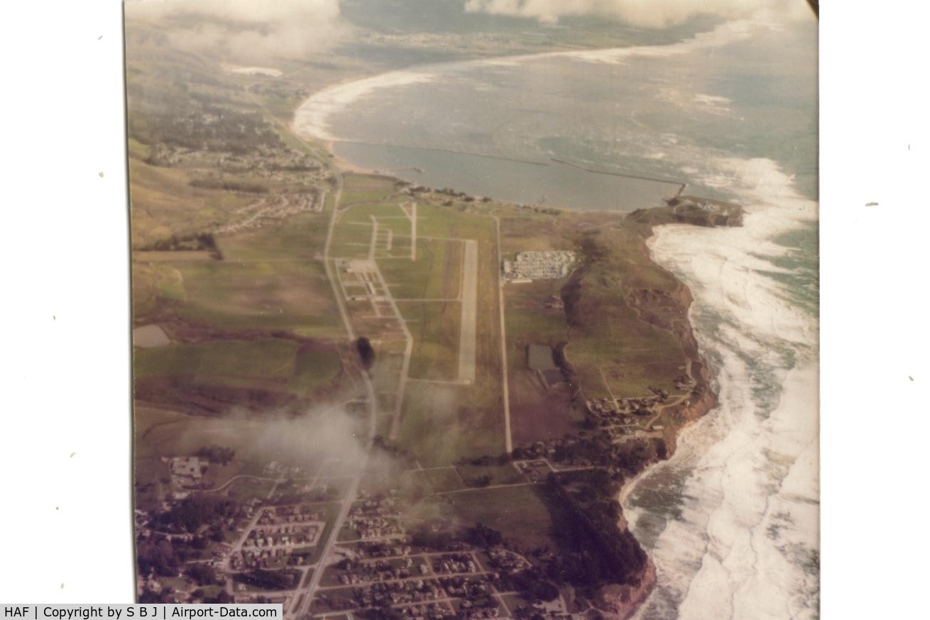 Half Moon Bay Airport (HAF) - Half Moon Bay airport in 1976 looking south. Notice the half moon shape water south of airport.Princeton at south end of airport (aircraft parking) is a very nice place to visit & eat at.Was my home base for six months till summer fog became untenable!!