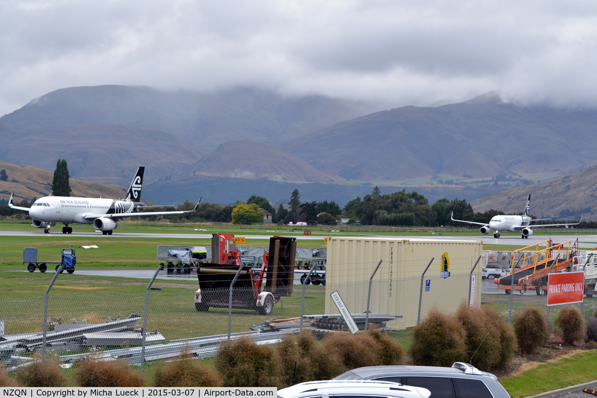 Queenstown Airport, Queenstown New Zealand (NZQN) - Two aircraft on the same active runway: The one on the left is taxing for take-off, and the one on the right just landed and is backtracking to the exit.