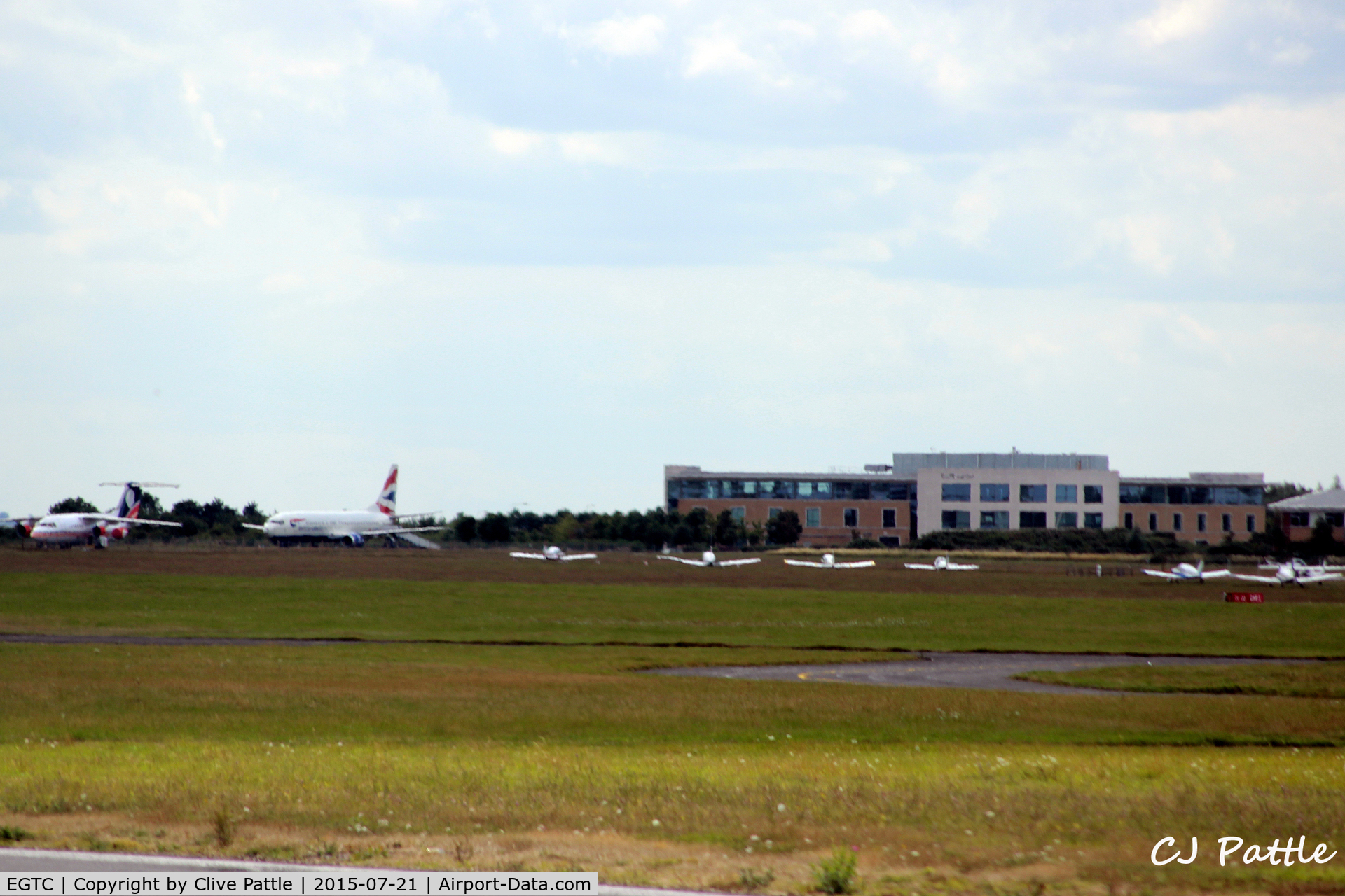 Cranfield Airport, Cranfield, England United Kingdom (EGTC) - Airport and Cranfield University buildings viewed from the runway at Cranfield EGTC. On the left are the two stored airliner instructional airframes, a BAe 146 and a B737.