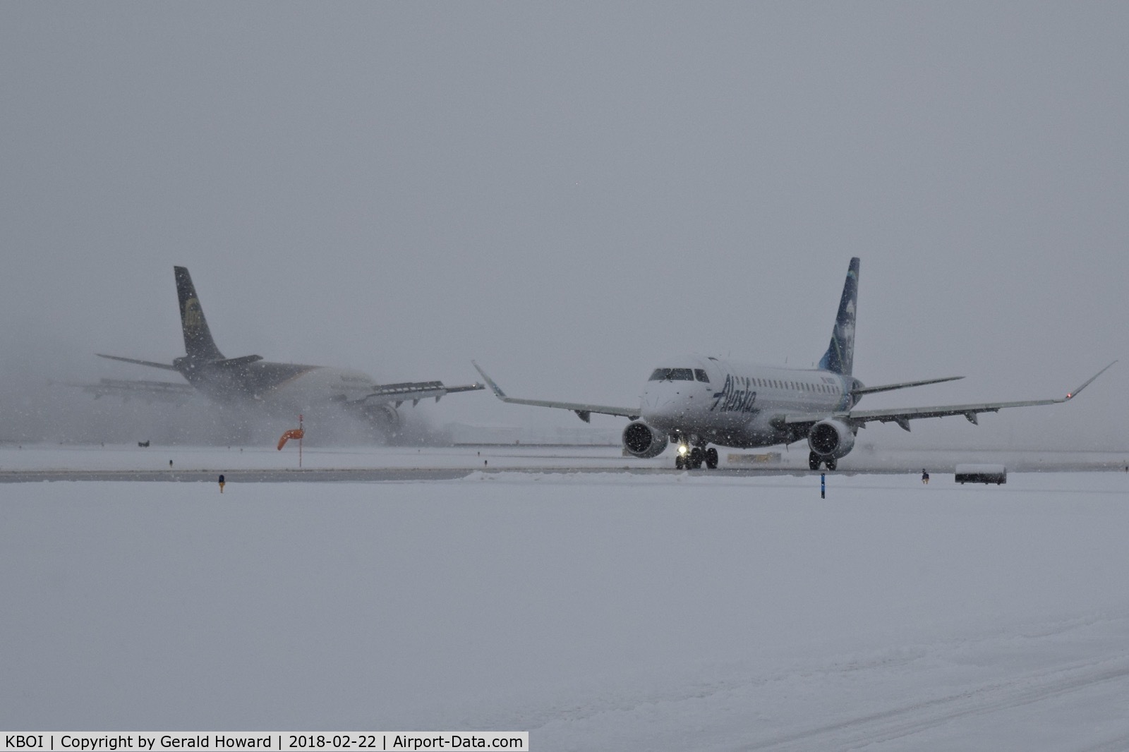 Boise Air Terminal/gowen Fld Airport (BOI) - Alaska taxiing on Alpha while UPS slows on a snow covered runway.
