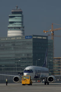 Vienna International Airport, Vienna Austria (VIE) - LOT Boeing 737 pushing back infront of the office park and the control tower - by Yakfreak - VAP