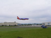 Snohomish County (paine Fld) Airport (PAE) - Southwest 737 landing 16R, Boeing wide body plant background left, paint hangars background right - by John J. Boling