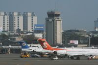 Kaohsiung International Airport - The old control tower over the domestic terminal with the tail of a F100 from Mandarin Airlines and an MD-90 from Uni Air - by Michel Teiten ( www.mablehome.com )